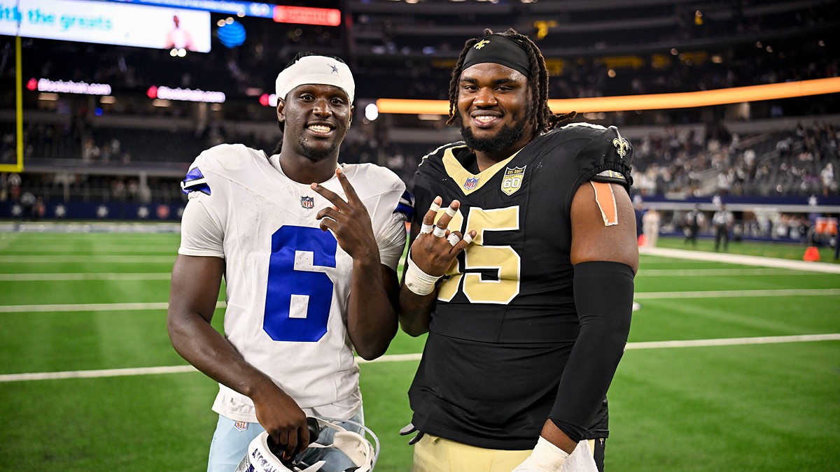 Dallas Cowboys wide receiver Camden Brown and New Orleans Saints guard Jeremiah Wright pose on the field postgame.