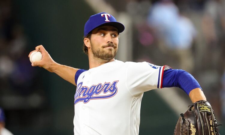 Texas Rangers pitcher Carter Baumler releases a pitch in his white home uniform at Globe Life Field.