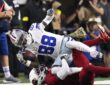 Dallas Cowboys wide receiver CeeDee Lamb reaches out with the ball as Arizona Cardinals cornerback Will Johnson tackles him.