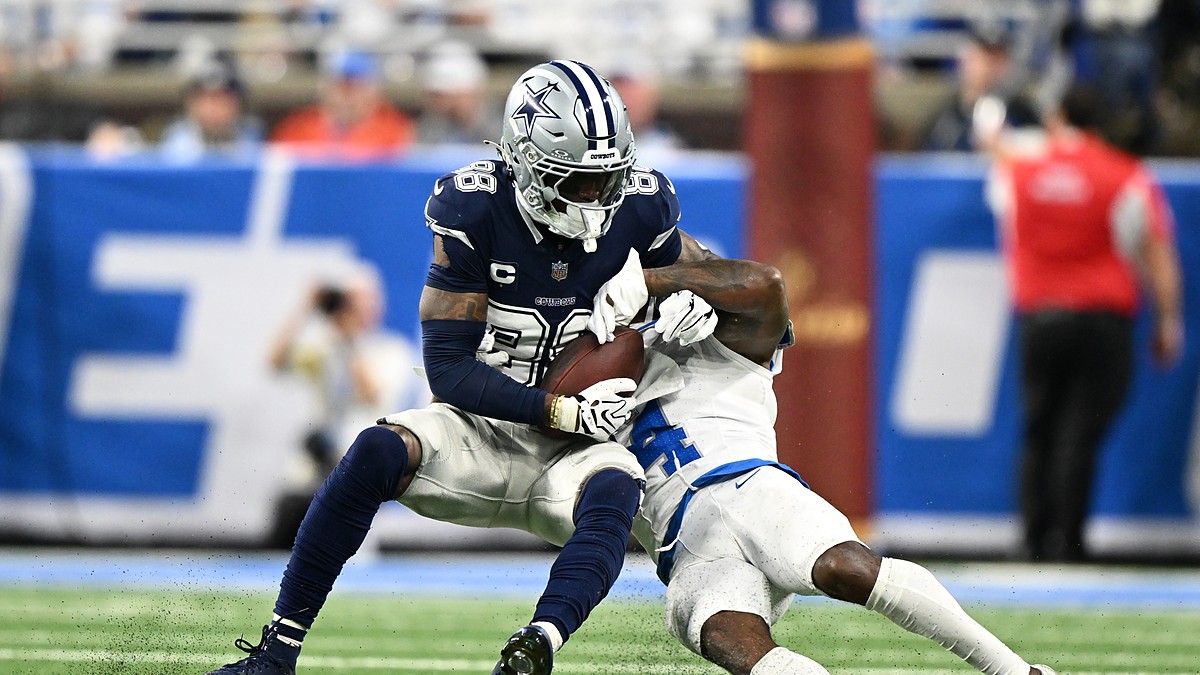 Dallas Cowboys wide receiver CeeDee Lamb secures a catch as Detroit Lions cornerback D.J. Reed wraps him up.