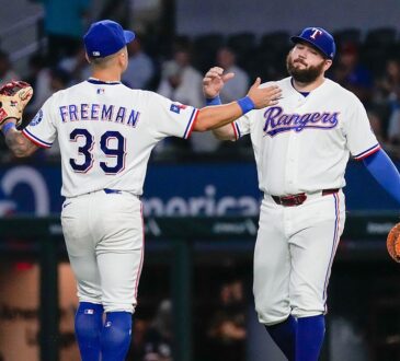 Texas Rangers third baseman Cody Freeman and first baseman Jake Burger slap hands on the field after a win.