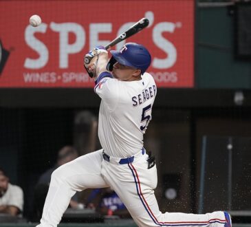 Texas Rangers shortstop Corey Seager makes contact with a pitch, the ball just off the bat in front of him.