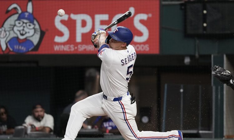 Texas Rangers shortstop Corey Seager makes contact with a pitch, the ball just off the bat in front of him.