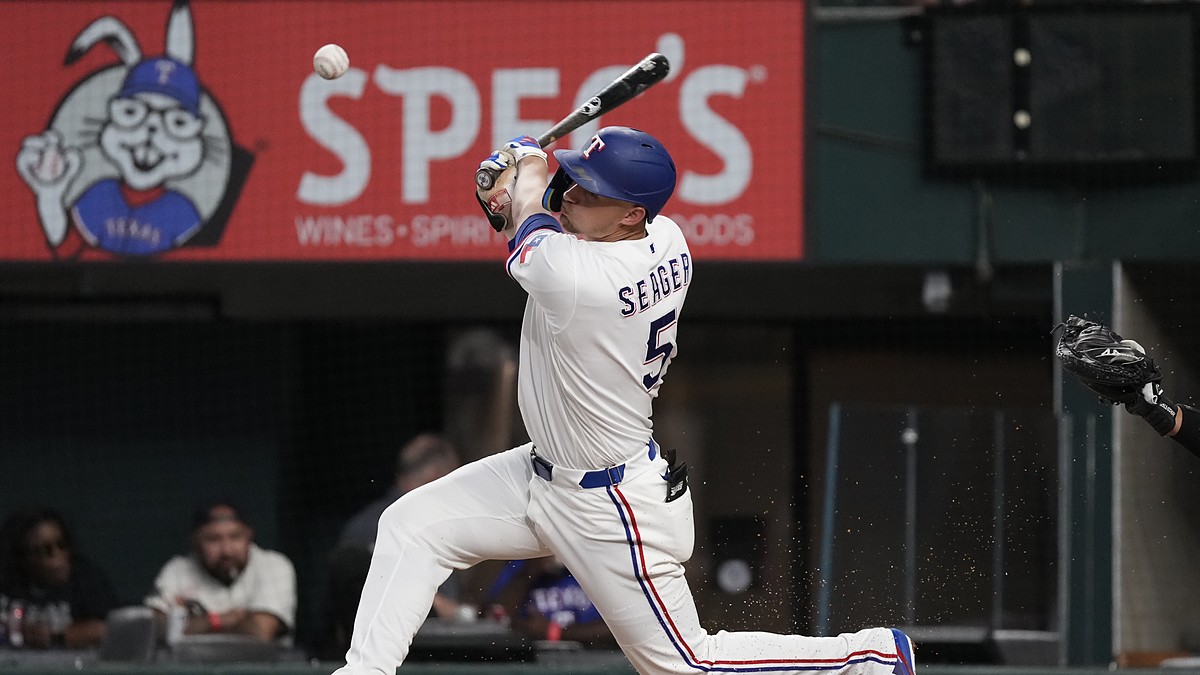Texas Rangers shortstop Corey Seager makes contact with a pitch, the ball just off the bat in front of him.