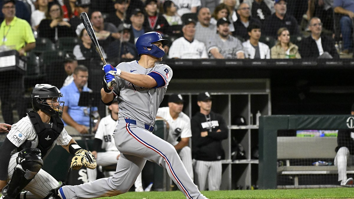 Texas Rangers shortstop Corey Seager follows through on a swing in a road grey uniform at Rate Field.