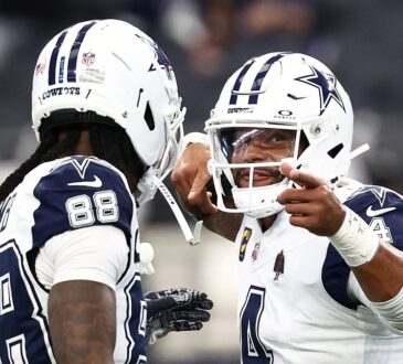 Dallas Cowboys quarterback Dak Prescott gestures while talking with wide receiver CeeDee Lamb during pregame warmups.