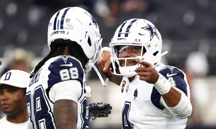 Dallas Cowboys quarterback Dak Prescott gestures while talking with wide receiver CeeDee Lamb during pregame warmups.