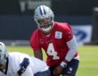 Dallas Cowboys quarterback Dak Prescott lines up under center as Cooper Beebe prepares to snap the ball.