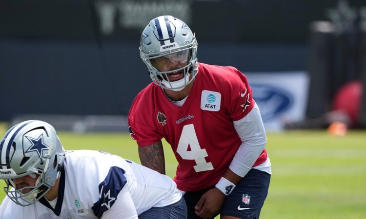 Dallas Cowboys quarterback Dak Prescott lines up under center as Cooper Beebe prepares to snap the ball.