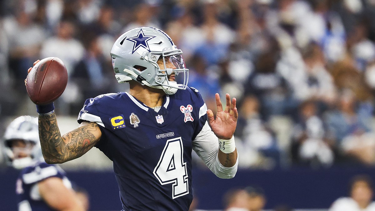 Dallas Cowboys quarterback Dak Prescott cocks the ball to throw in a navy No. 4 jersey.