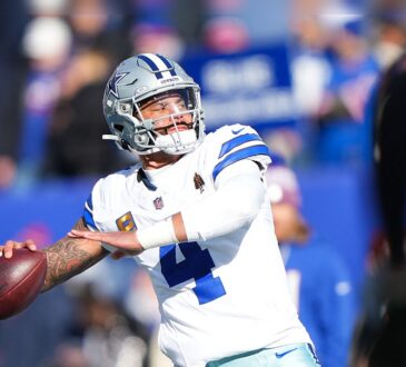 Dallas Cowboys quarterback Dak Prescott cocks his arm to throw during warmups in a white No. 4 jersey.