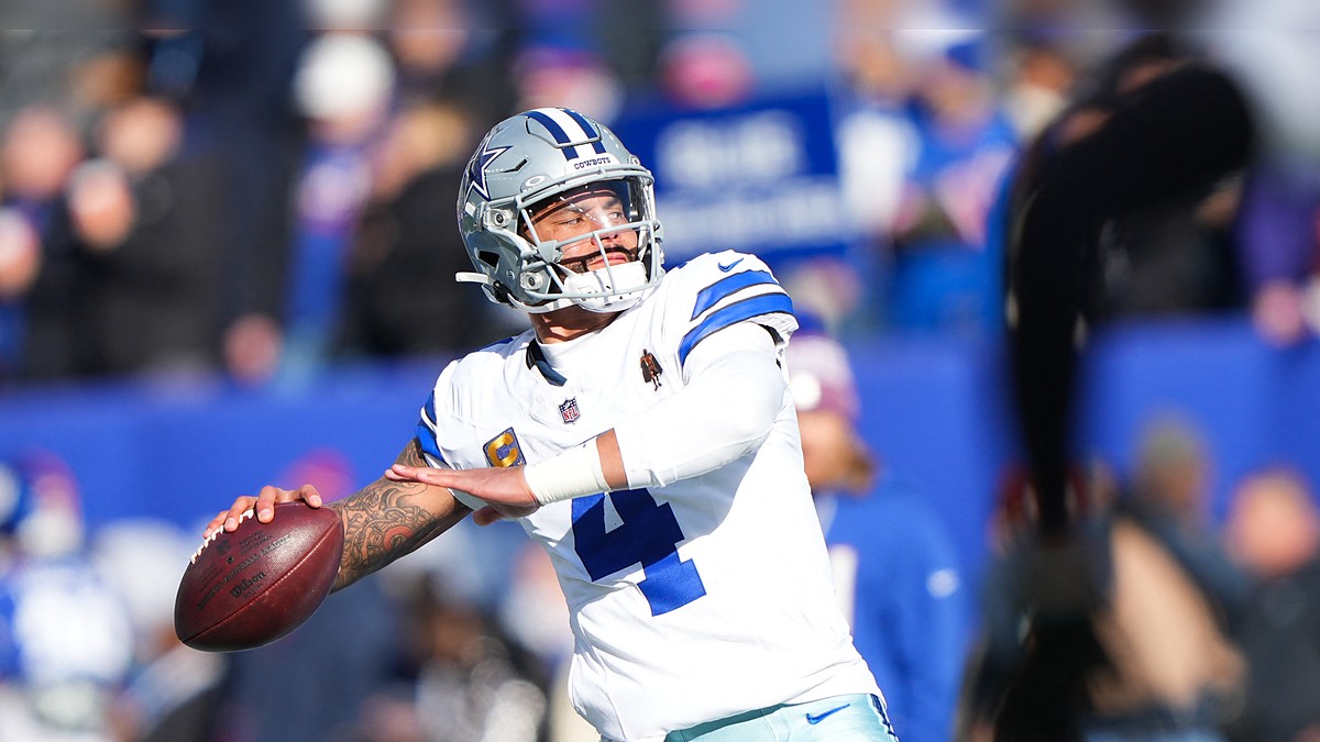 Dallas Cowboys quarterback Dak Prescott cocks his arm to throw during warmups in a white No. 4 jersey.