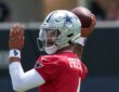 Dallas Cowboys quarterback Dak Prescott cocks the football behind his helmet in his throwing motion.