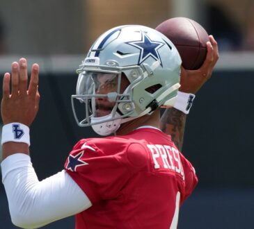 Dallas Cowboys quarterback Dak Prescott cocks the football behind his helmet in his throwing motion.