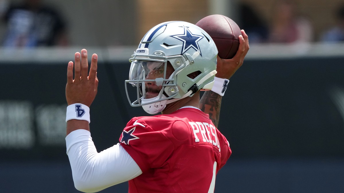 Dallas Cowboys quarterback Dak Prescott cocks the football behind his helmet in his throwing motion.