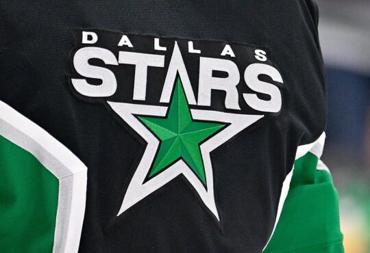 The Dallas Stars crest, a green star ringed in white, stitched on goaltender Jake Oettinger's black jersey.