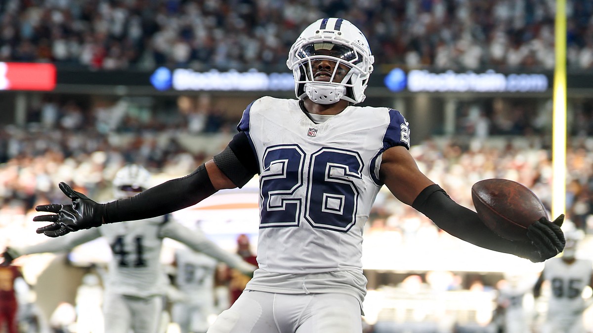 Dallas Cowboys cornerback DaRon Bland spreads his arms with the ball in one hand after an interception return.