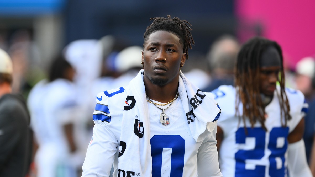 Dallas Cowboys linebacker DeMarvion Overshown stands on the sideline in uniform with a towel around his neck.