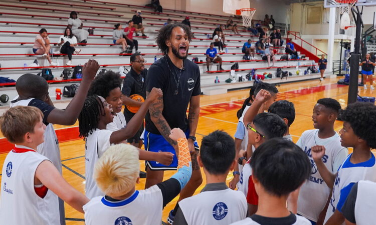 Dallas Mavericks center Dereck Lively II fires up a huddle of young campers at a Mavs Academy hoop camp.
