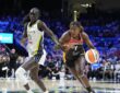 Connecticut Sun forward Diamond Miller drives the baseline with the ball as Dallas Wings forward Awak Kuier defends.