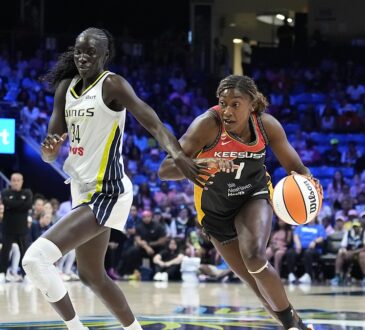 Connecticut Sun forward Diamond Miller drives the baseline with the ball as Dallas Wings forward Awak Kuier defends.