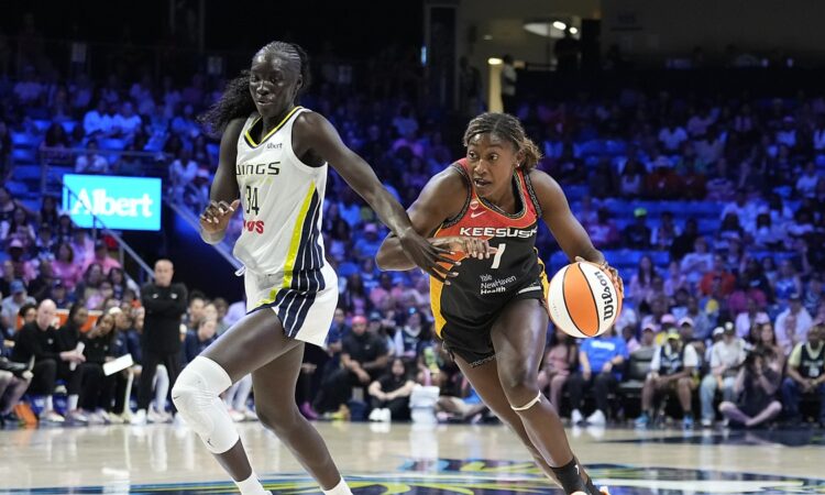 Connecticut Sun forward Diamond Miller drives the baseline with the ball as Dallas Wings forward Awak Kuier defends.