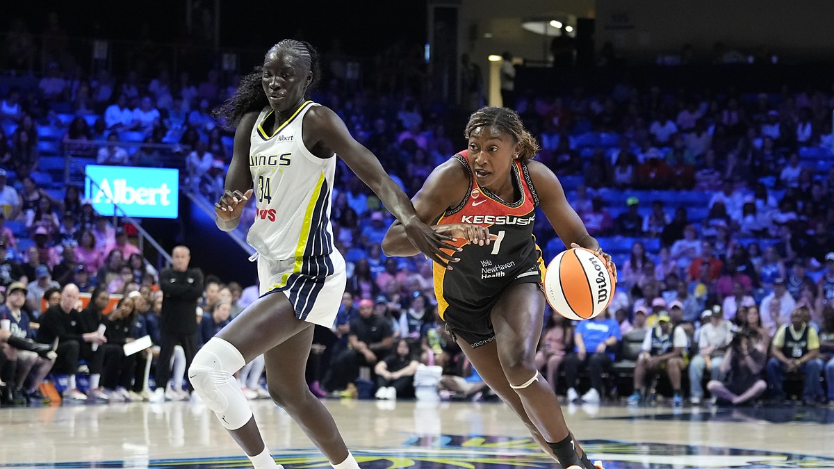 Connecticut Sun forward Diamond Miller drives the baseline with the ball as Dallas Wings forward Awak Kuier defends.