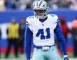 Dallas Cowboys defensive end Donovan Ezeiruaku roars with his arms flexed after a play in his white No. 41 jersey.
