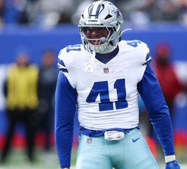 Dallas Cowboys defensive end Donovan Ezeiruaku roars with his arms flexed after a play in his white No. 41 jersey.