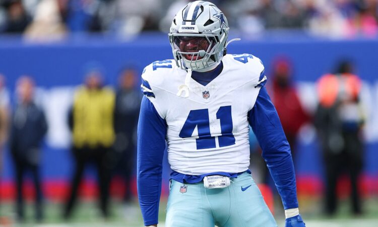 Dallas Cowboys defensive end Donovan Ezeiruaku roars with his arms flexed after a play in his white No. 41 jersey.