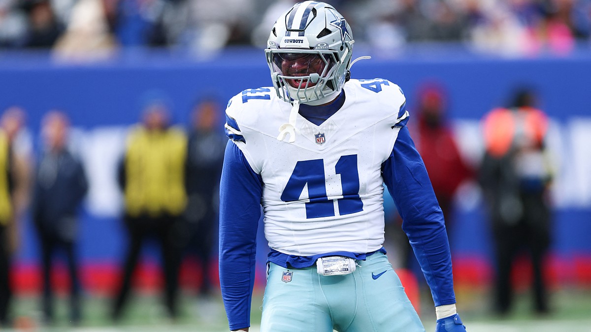 Dallas Cowboys defensive end Donovan Ezeiruaku roars with his arms flexed after a play in his white No. 41 jersey.