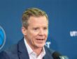 Dallas Mavericks head coach Dusty May speaks into a microphone at his introductory press conference.