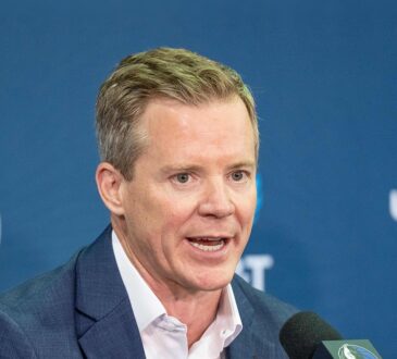 Dallas Mavericks head coach Dusty May speaks into a microphone at his introductory press conference.
