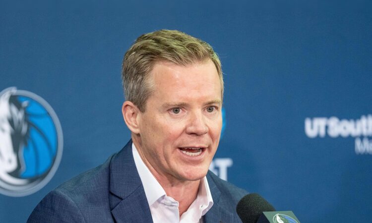 Dallas Mavericks head coach Dusty May speaks into a microphone at his introductory press conference.