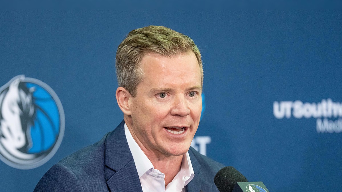 Dallas Mavericks head coach Dusty May speaks into a microphone at his introductory press conference.