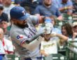 Texas Rangers batter Ezequiel Durán drives a pitch in his gray road uniform at American Family Field.