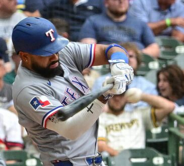 Texas Rangers batter Ezequiel Durán drives a pitch in his gray road uniform at American Family Field.