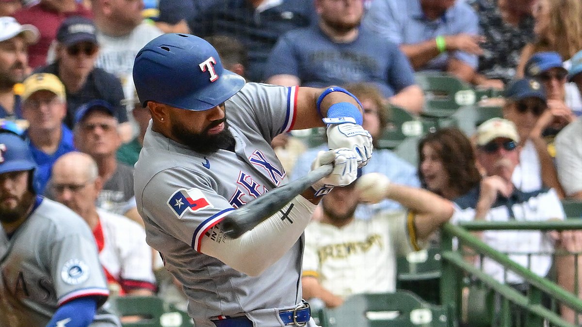 Texas Rangers batter Ezequiel Durán drives a pitch in his gray road uniform at American Family Field.