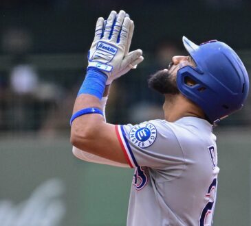 Texas Rangers batter Ezequiel Durán raises his hands and looks skyward after reaching base at American Family Field.