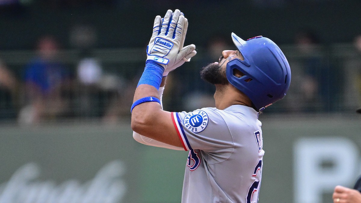 Texas Rangers batter Ezequiel Durán raises his hands and looks skyward after reaching base at American Family Field.