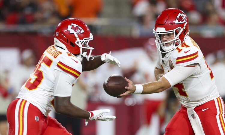 Kansas City Chiefs quarterback Garrett Nussmeier hands the ball to running back Emari Demercado in a preseason game.