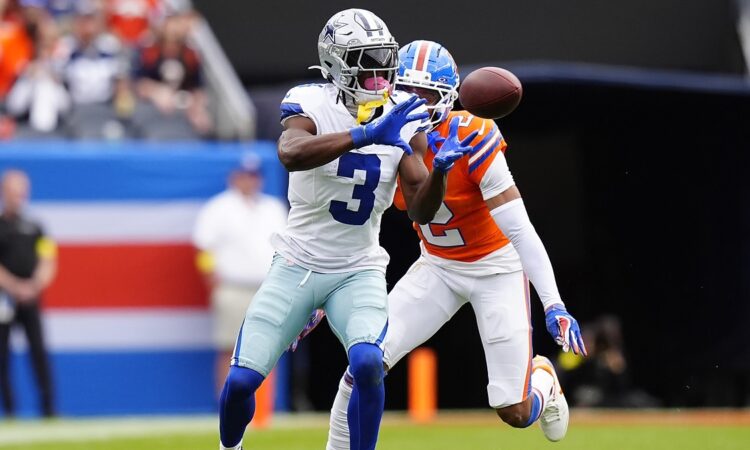 Dallas Cowboys wide receiver George Pickens hauls in a catch as Broncos cornerback Patrick Surtain II defends.