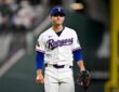 Texas Rangers starting pitcher Jack Leiter walks off the field with his glove after finishing an inning.