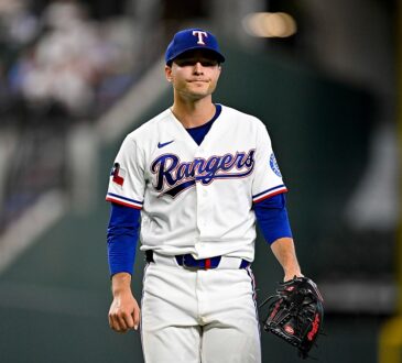 Texas Rangers starting pitcher Jack Leiter walks off the field with his glove after finishing an inning.