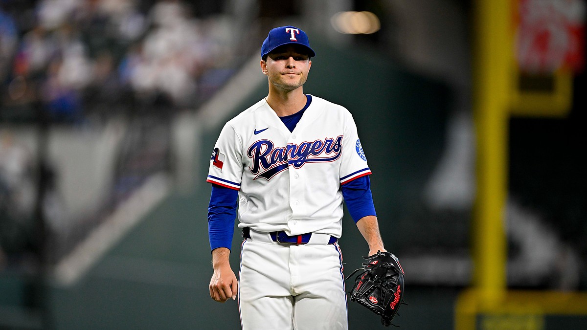 Texas Rangers starting pitcher Jack Leiter walks off the field with his glove after finishing an inning.