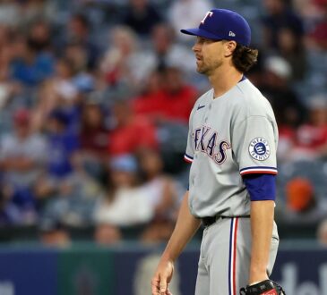 Rangers pitcher Jacob deGrom releases a pitch from the mound in a home white uniform