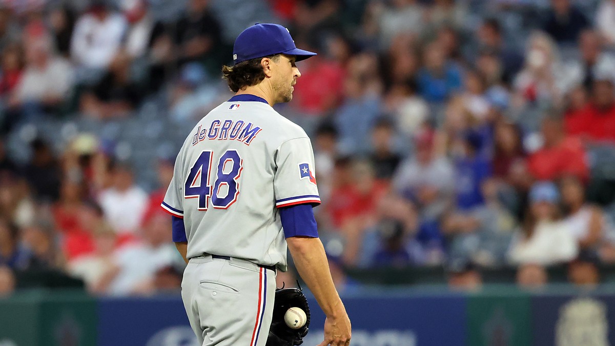 Rangers pitcher Jacob deGrom stands on the mound holding the ball after giving up a hit