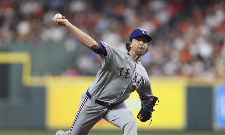 Texas Rangers starting pitcher Jacob deGrom delivers a pitch in his gray road uniform against the Astros.