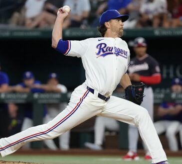 Alt Text: Texas Rangers pitcher Jacob deGrom delivers a pitch at Globe Life Field, the ball cocked behind his head.