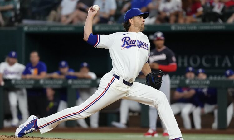 Alt Text: Texas Rangers pitcher Jacob deGrom delivers a pitch at Globe Life Field, the ball cocked behind his head.